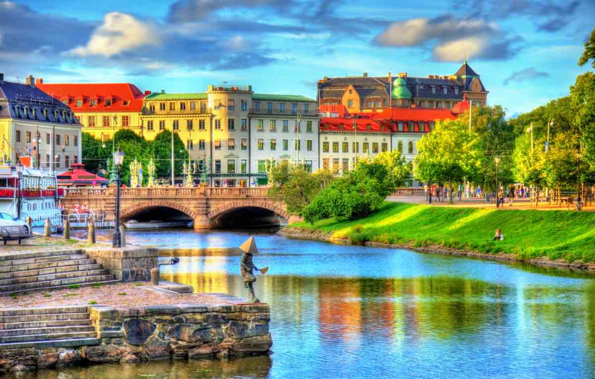 Scenic view of a canal, historic bridge and colorful buildings in Gothenburg, Sweden on a sunny day.