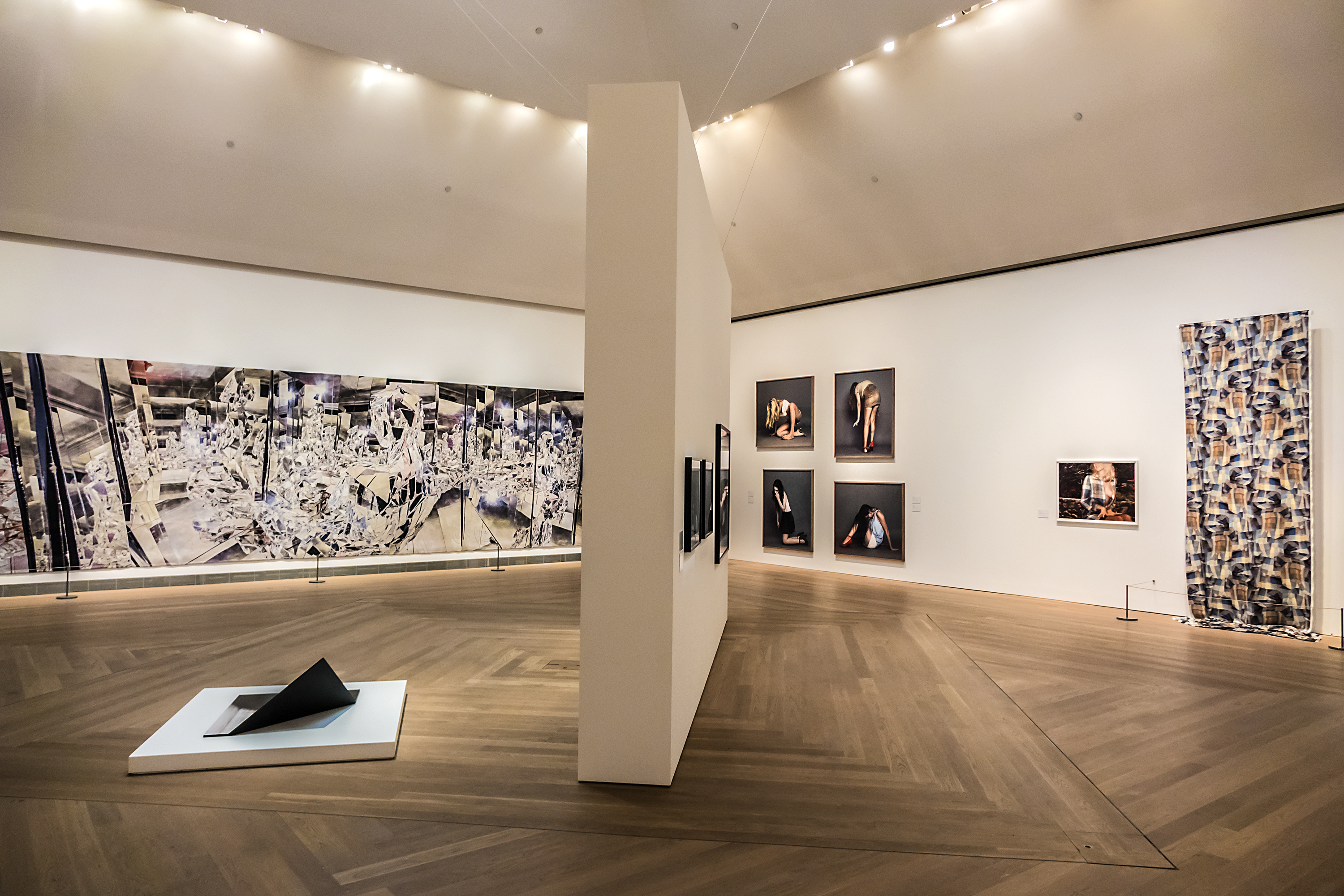 Ausstellungen im Moderna Museet Innenansicht einer Ausstellungshalle im Moderna Museet mit zeitgenössischen Kunstinstallationen und Fotografien auf minimalistischen weißen Wänden, mit Holzboden und sanfter Beleuchtung.